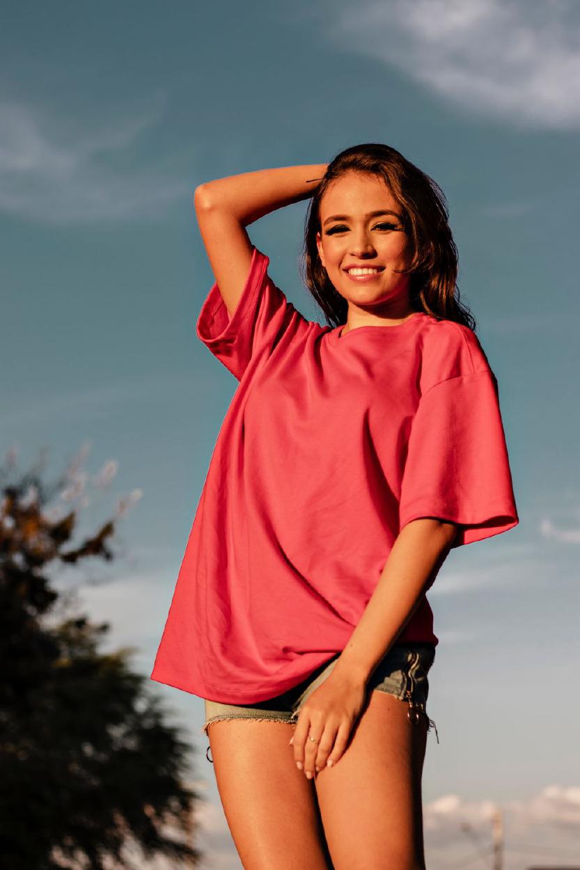 Young woman in a plain tee, smiling in the sunlight